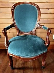A beautiful and comfortable Victorian armchair on four coasters. Hard wood (possibly walnut), blue/turquoise velvet...