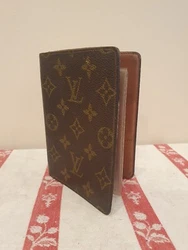 Portefeuille en toile monogram marron de la Maison LOUIS VUITTON. Trace de colle et usures de l age.