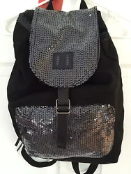 The material is black canvas and the pocket and flap has sequins. The inside is lined and has a zipper pocket and a...