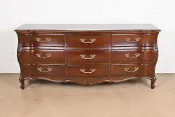 An exceptional French Provincial Louis XV style nine-drawer dresser or credenza. Carved cherry wood, with original...