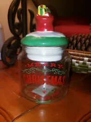 This is a clear glass canister. This lid has a seal on it. Very cute ! The lid knob are that of red bag filled with...