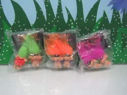 They have green, orange, and fuchsia hair. They are new, in a plastic envelopes.