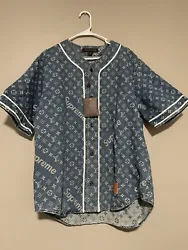 This Louis Vuitton x Supreme denim baseball shirt is perfect for any stylish man. The shirt features short sleeves, a...