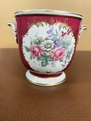 Pretty planter with handles, gold trim and flowers on front and back.