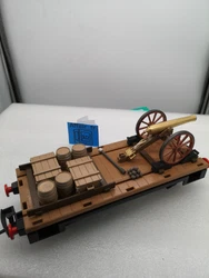 1 WAGON PLAT + 1 CANON ACW 3D + caisses et tonneaux 3D. Les caisses et tonneaux sont collées sur le plateau du wagon....