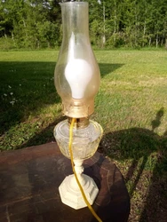 Lamp has a yellow tint pressed glass center and white metal base with design engraved in it. Smoky tint color to shade....