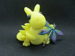 This dragon is holding his favorite dragonfly.