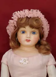 Here is a very lovely and large wax over papier mache doll that has been dressed beautifully. She has been repainted...