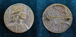 Cette belle et rare broche en laiton plaqué argent contient un portrait de Jeanne DArc, des fleurs de lys et la croix...