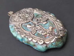 Charmant pendentif ethnique venant du Tibet, assez ancien, en métal argenté (50% environ) ornant une très belle...