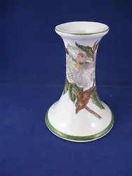 This is a porcelain candle holder. It stands appx. It is white, with green trim, and a raised floral decoration. Very...