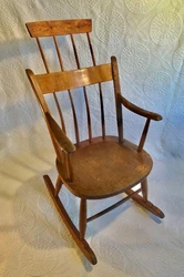 This early to mid-19th century New England pine Windsor rocker shows comb back styling with an extended shawl rack and...