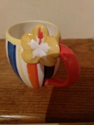 This mug color are gorgeous tropical stripes. It looks like a Surfboard. Near the handle there is a yellow hybiscus...