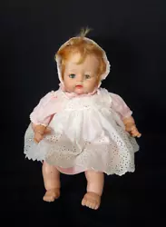 She is a blonde, vinyl doll with a cloth body and is 19” in overall height. She is dressed in original dress with...