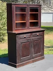 This two piece glass door hutch features two wide beveled glass doors opening to reveal two removable shelves for...