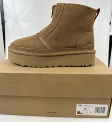 Heat-embossed UGG® logo. Round-toe booties with front zipper closure. 1-3/4