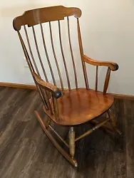 The retro rocking chair made by Nichols & Stone Co. (Gardner, Massachusetts) features a beautiful spindle back, turned...