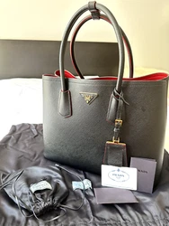 This Prada Double tote is crafted in Saffiano leather. It features a double handle, detachable shoulder strap and nappa...
