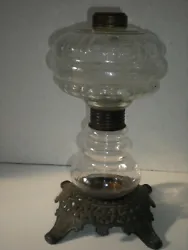 Up for sale is a Antique two tier glass oil lamp on Cast iron base. The bottom globe has a white speckle pattern inside...