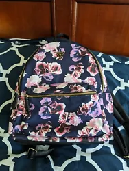 This designer backpack from GUESS features a beautiful navy blue color with a vibrant purple and pink floral design,...