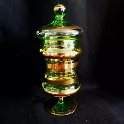 The hand-blown multi tiered bulbed glass jar body is accented with stripes of abstract ribbed gold patterns, and it...