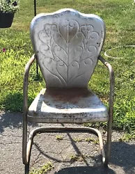 This is a fantastic vintage patio chair! Its clam shell back is embossed with some beautiful heart shaped scrolls. The...