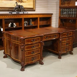 This desk features brass hardware, hand carved edging, claw foot and detailing, with 9 dove tail drawers on each side....
