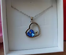Poids : 9,30 g. Un petit coeur argenté est accolé au coeur en cristal bleu.