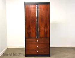 A mid century modern rosewood and black lacquered armoire dresser with chrome accents in the style of Harvey Probber...