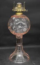This pink glass oil lamp has a spherical font with a circle or dot pattern, and the base has beaded panels. I dont know...