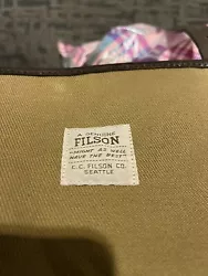 This Filson Rugged Twill Rolling 2-Wheel Check-In Bag is the perfect travel companion for those who value durability...