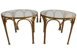 Matching pair of Hollywood Regency gilt metal rope and tassel round end tables with smoked glass tops.Condition is very...