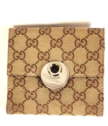 Features a change purse on one side with a snap closure covered by Gucci silver hardware. Made in Italy. Bi-fold has...