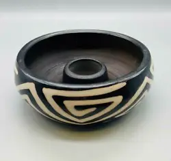 A bowl shaped design with a wide base and rounded sides, decorated with black and white design. The center hole is 1