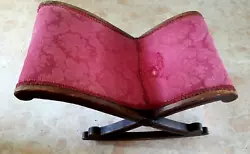 Because it cradled painful feet and rocked with a rocking chair. Made of mahogany wood. And the upholstery shows wear...