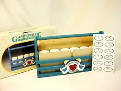 New in original box and dated 1987. Features painted blue rack tote with handle. 2 geese on front with 6 clear jars,...