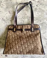 Vintage Christian Dior brown monogram fabric with 2 leather straps and single snap button closure has clearly been well...