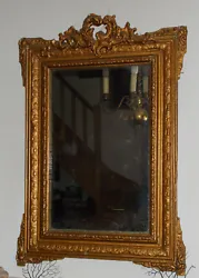 Rare miroir mural à fronton en stucs doré. de style Napoléon III. Belle et large moulure en bois et stucs dorés.