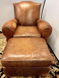 An iconic, antique leather cigar chair and matching ottoman.Dimensions of seat height: 16.5