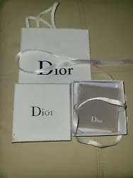 Pouch is gray velvet with white logo and white ribbon tie closure. Ribbon is satin with black logo. There is a small...