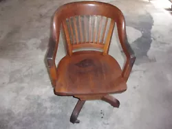 Wooden Banker Chair. Used, piece split at one end in backrest. Left side of mount is loose. Usable, swivels and...