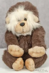 He has beige and brown plush with white longer fur around his face. He has brown plastic safety eyes and a black...