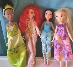 Includes all 4 dolls as pictured: Ariel, Jasmine, Rapunzel, and Tiana. All of them have dresses on, although Im not...