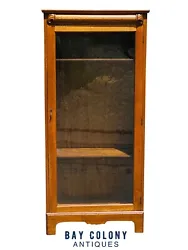 The bookcase retains its original wavy glass & brass handle. The bookcase is finished in a warm golden oak color & is...