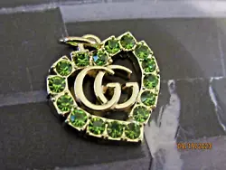 1 GUCCI HEART CHARM. WITH GREEN COLOR RHINESTONES.