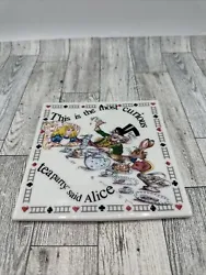 Alice in Wonderland trivet tile in good, pre-owned condition. Minor scuff/signs of use.
