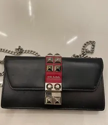 Prada Elektra Bag. Black and red leather small bag with Silver/metal strap and studs. 