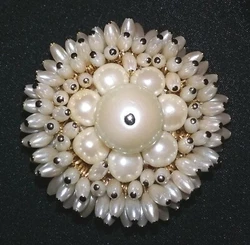 This attractive brooch has faux pearls with gold tone pins and gold tone backing. Very good preowned condition.