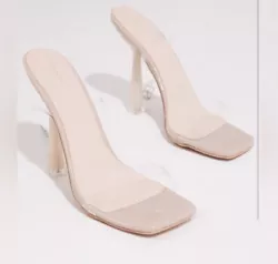 We are obsessed with these heels to take your look to the next level. Featuring a clear heel, a single strap and a nude...