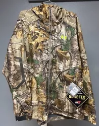 UA GORTEX Real Tree Camo Jacket. Size 2XL, has hood, zipper closure in front with storm flap, zipper pockets and...